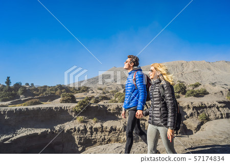 Young couple man and woman visit the Bromo volcano at the Tengger Semeru National Park on the Java 57174834