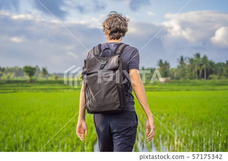 Male tourist with a backpack goes on the rice field 57175342