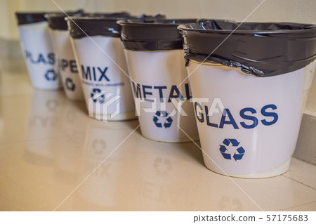 Garbage cans. Trash bins with sorted garbage in kitchen cabinet with segregated household garbage - 57175683