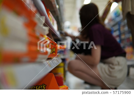 Woman choosing sweets at the supermarket Woman choosing sweets at the supermarket 57175900