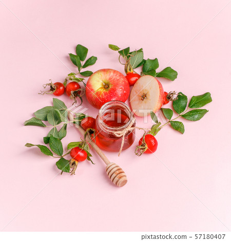 Fresh rose hip berries, apple and honey on pink Fresh rose hip berries, apple and honey on pink 57180407