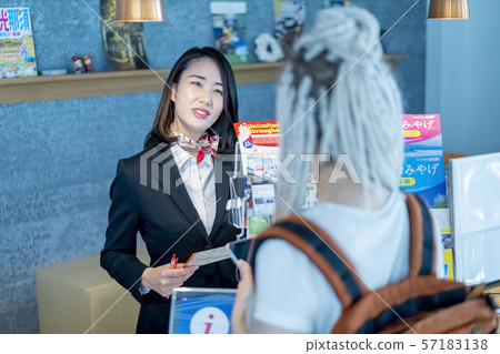 一個華麗的女性工作人員,在外國人的旅遊信息中心禮貌和友好 一個華麗的女性工作人員,在外國人的旅遊信息中心禮貌和友好 57183138