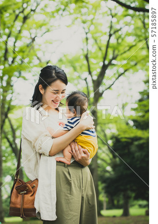 抱著嬰孩育兒育兒家庭公園新綠色的年輕母親 57185897