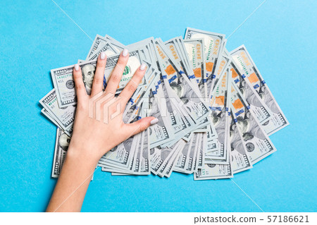 Female hand lying on stack of one hundred dollar Female hand lying on stack of one hundred dollar 57186621