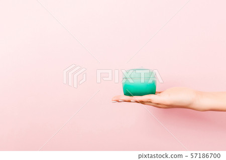 Female hand holding cream bottle of lotion Female hand holding cream bottle of lotion 57186700