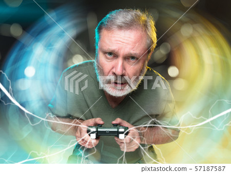 Enthusiastic gamer. Joyful man holding a video game controller Enthusiastic gamer. Joyful man holding a video game controller 57187587