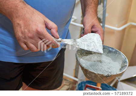 Scraper and plasterer's scoop with gypsum powder 57189372