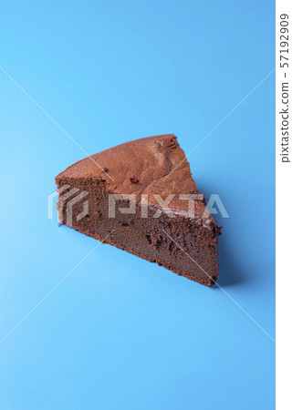 One slice of Kladdkaka on a blue background. One slice of Kladdkaka on a blue background. 57192909