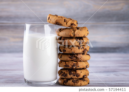 A stack of chocolate chip cookies lies near a 57194411