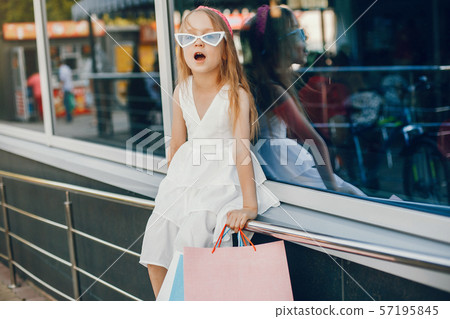 Cute little girl with shopping bag in a city Cute little girl with shopping bag in a city 57195845