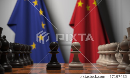 Flags of the EU and China behind chess board. The first pawn moves in the beginning of the game 57197483