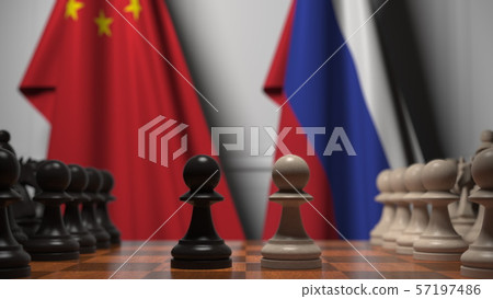 Flags of China and Russia behind chess board. The first pawn moves in the beginning of the game 57197486