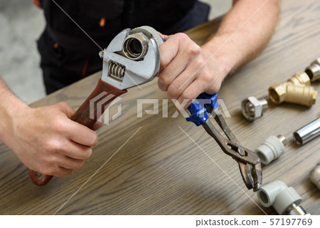 A worker is connecting elements of the plumbing. 57197769