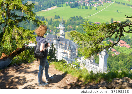 Young woman looks at Neuschwanstein castle, Young woman looks at Neuschwanstein castle, 57198318