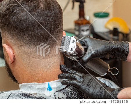 Stylist cutting hair on males nape in barbershop Stylist cutting hair on males nape in barbershop 57201156