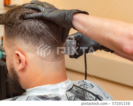 Stylist holding clients nape and cutting hair with Stylist holding clients nape and cutting hair with 57201158