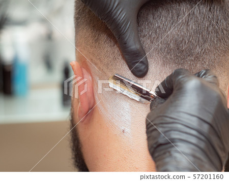 Hairstylist shaving clients neck with straight Hairstylist shaving clients neck with straight 57201160