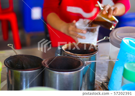 Woman's hands preparing traditional iced coffee cup - traditional coffee drink - fresh coffee drink preparation 57202391