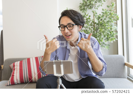 A man shooting a video with his smartphone A man shooting a video with his smartphone 57202421