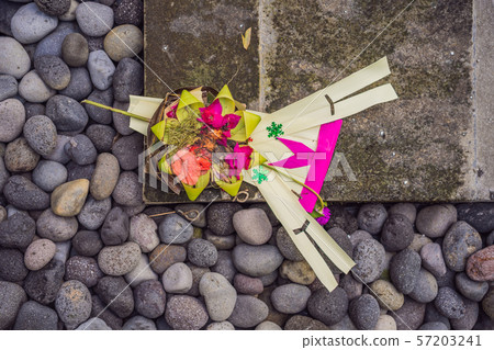 Traditional balinese offerings to gods in Bali with flowers and aromatic sticks Traditional balinese offerings to gods in Bali with flowers and aromatic sticks 57203241