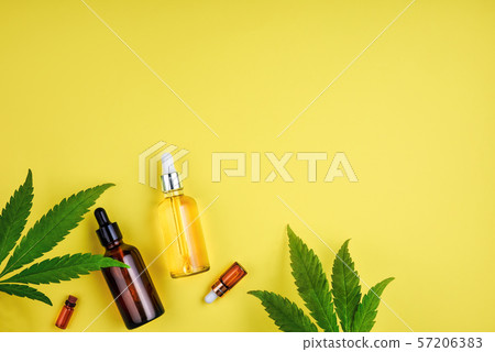 Bottles with CBD oil, a dropper, and leaf marijuana on yellow background Bottles with CBD oil, a dropper, and leaf marijuana on yellow background 57206383