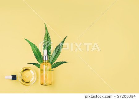 Bottle with CBD oil, pipette, capsules and cannabis leaf on a yellow background Bottle with CBD oil, pipette, capsules and cannabis leaf on a yellow background 57206384