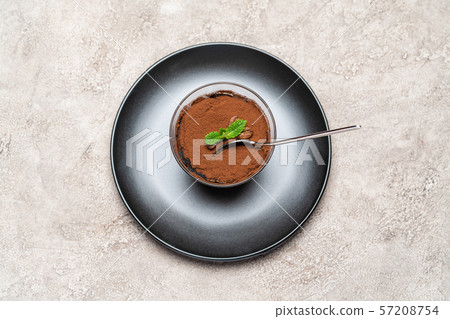 Portion of Classic tiramisu dessert in a glass cup on concrete background Portion of Classic tiramisu dessert in a glass cup on concrete background 57208754