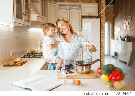 Mother and daughter prepares pastry with chocolate Mother and daughter prepares pastry with chocolate 57209694