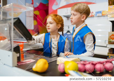 Girl and boy in uniform at the register, sellers Girl and boy in uniform at the register, sellers 57210250