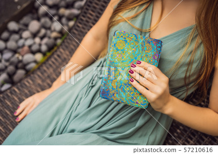 Woman reads e-book on deck chair in the garden 57210616