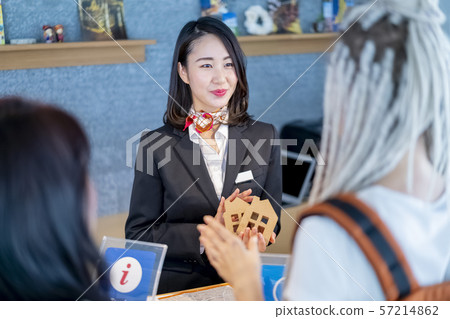 A smiling female real-estate guide receptionist who guides visitors to the Olympics for long-term hotel rental properties 57214862