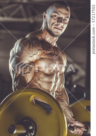 Brutal strong men workout bodybuilding background - muscular bodybuilder men doing exercises in gym 57217502
