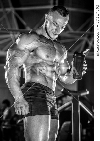 Brutal strong men workout bodybuilding background - muscular bodybuilder men doing exercises in gym 57217503