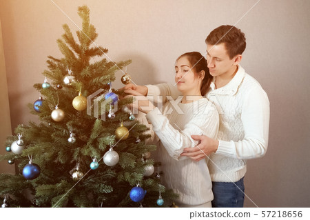 man stands behind lady helps decorating christmas tree man stands behind lady helps decorating christmas tree 57218656