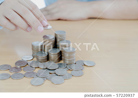 Businessman hand coins in finger and row stacks Businessman hand coins in finger and row stacks 57220937