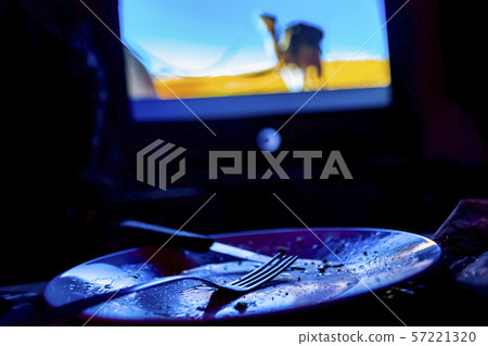 empty plate in front of tv - lonely night 57221320
