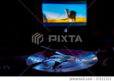 empty plate in front of tv - lonely night 57221321