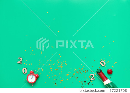 Champagne bottle, glitter, alarm clock and 2020 text. Flat lay of new year, christmas eve 57221708