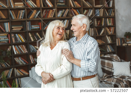 Senior couple together at home retirement concept standing laughing Senior couple together at home retirement concept standing laughing 57222507