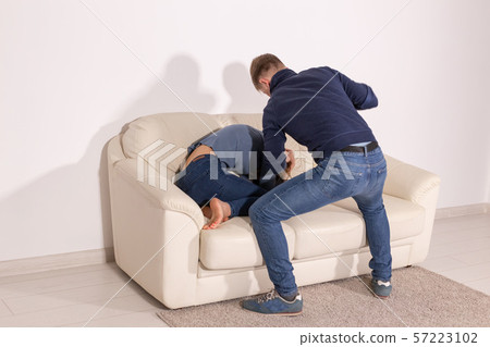 people, abuse and violence concept - angry aggressive husband trying to hit his wife people, abuse and violence concept - angry aggressive husband trying to hit his wife 57223102