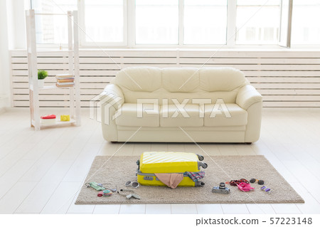 Trip, travel and holidays concept - collecting things for the trip in suitcase Trip, travel and holidays concept - collecting things for the trip in suitcase 57223148