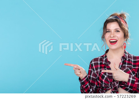Positive beautiful young woman in a plaid vintage shirt looking at the camera and smiling posing on Positive beautiful young woman in a plaid vintage shirt looking at the camera and smiling posing on 57223269