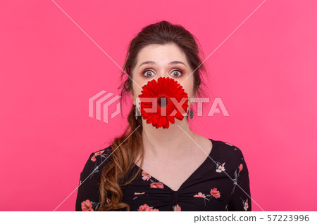 Emotions, flowers and people concept - Happy woman having fun with gerbera flowers 57223996