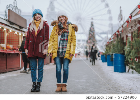 Friendly girls standing in the middle of festive market 57224900