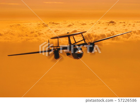 US Navy aircraft carrier E-2C Hawkeye early warning aircraft flying in the sea of clouds dyed by a beautiful sunset 57226586