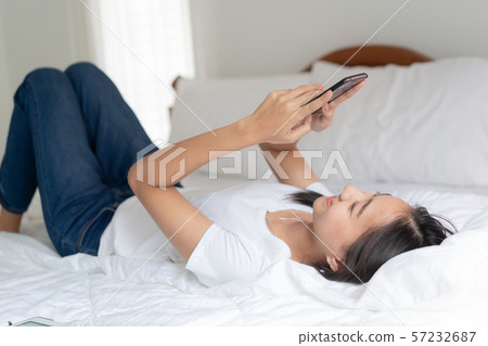 Beautiful young Asian women are using smartphone to chat with friend Beautiful young Asian women are using smartphone to chat with friend 57232687