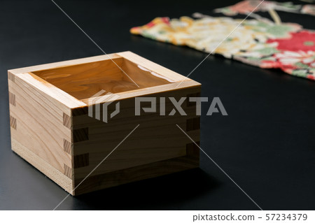 Moment of pouring sake into a bowl over a Japanese pattern on a black background Moment of pouring sake into a bowl over a Japanese pattern on a black background 57234379