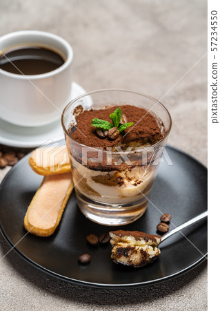Portion of Classic tiramisu dessert in a glass cup and espresso coffee on concrete background 57234550