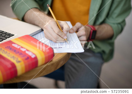 Man holding pencil and making test in foreign language 57235091