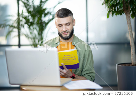 Bearded businessman studying modern Japanese vocabulary 57235106